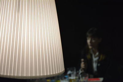 Side view of a man sitting on table at night