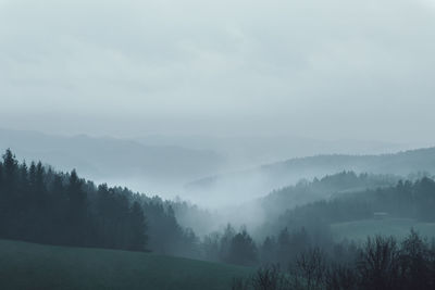 Scenic view of landscape against sky during foggy weather