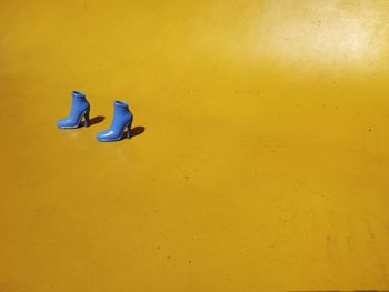View of high heels over yellow background