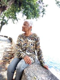 Young man sitting on rock