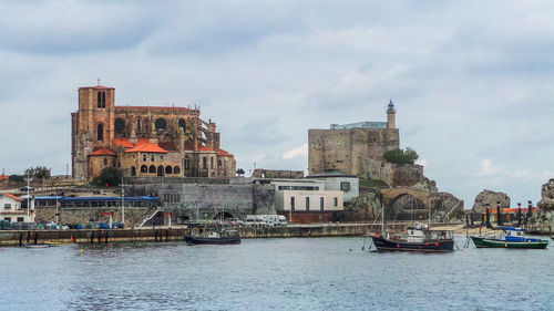 Boats in river with buildings in background