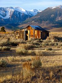 Abandoned built structure on field against mountain range