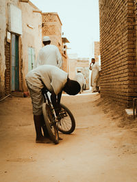 Side view of man riding motor scooter on street