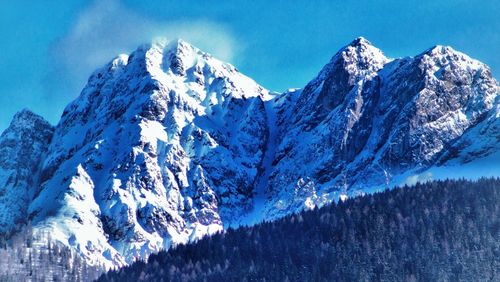 Panoramic shot of snowcapped mountains against blue sky