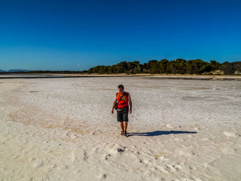 Full length of man standing at beach on sunny day