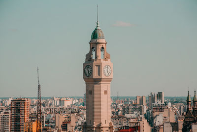 Clock tower in city against sky