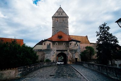 Facade leading towards church against sky