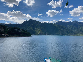 Scenic view of lake by mountains against sky