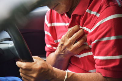 Midsection of man with heart attack while sitting in car