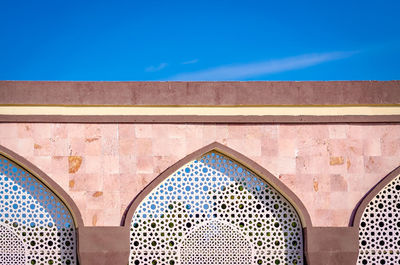 Low angle view of ornate building against blue sky