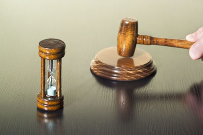 High angle view of gavel with hourglass on wooden table