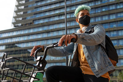 Low angle view of man sitting in city