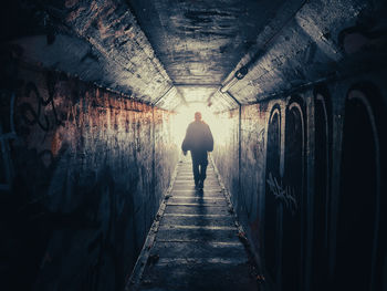 Rear view of man standing in tunnel