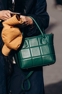 Midsection of woman holding bag