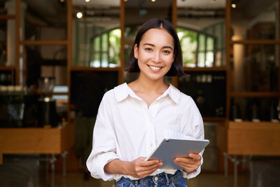 Portrait of young woman using phone