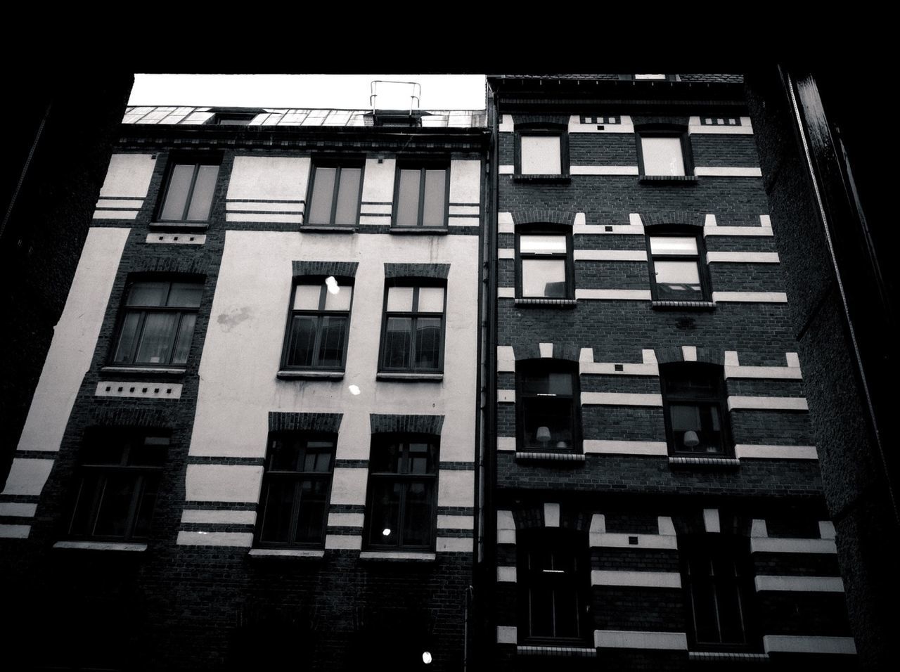 architecture, window, built structure, building exterior, low angle view, building, glass - material, residential building, residential structure, balcony, no people, day, sunlight, city, facade, indoors, in a row, repetition, house