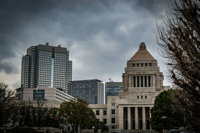 Low angle view of buildings against cloudy sky