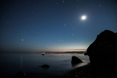 Scenic view of sea against clear sky at night