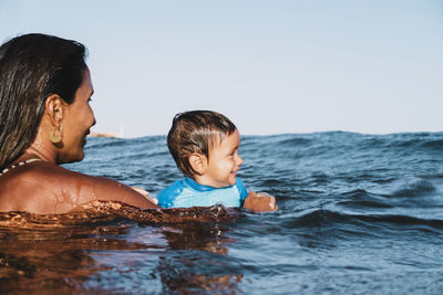 Portrait of mother and son playing at sea