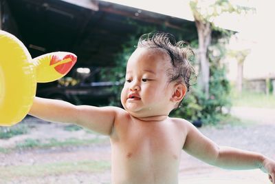 Portrait of shirtless boy looking at camera