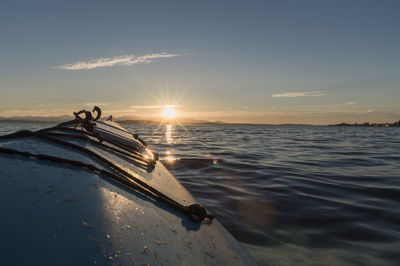 Kayak on sea against sky during sunset