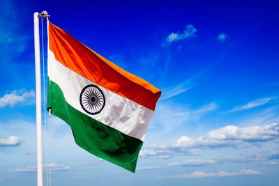 Low angle view of indian flag against blue sky