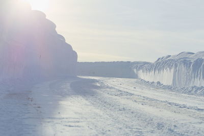 Snow covered land against sky