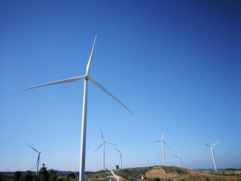 Windmills against clear blue sky