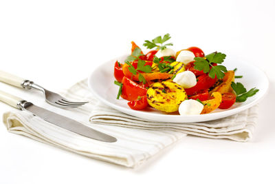 Close-up of fruits in plate against white background
