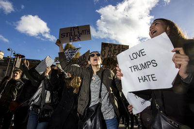 Low angle view of people standing against sky