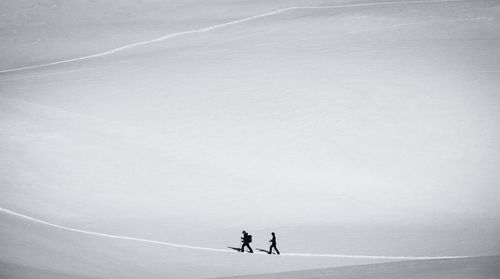 People skiing on snow against sky