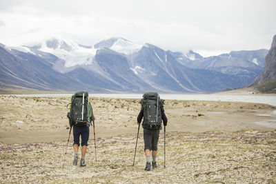 Two backpackers hiking in auyuittuq national park, canada.