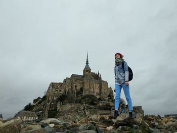 Girl standing on rocks against the mont saint michel