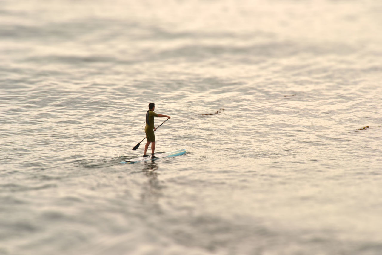 FULL LENGTH OF MAN SURFING ON SEA