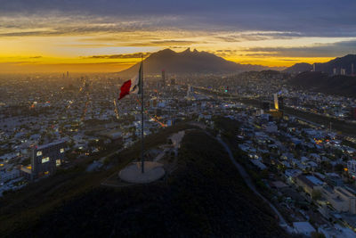 High angle view of illuminated cityscape against sky during sunset