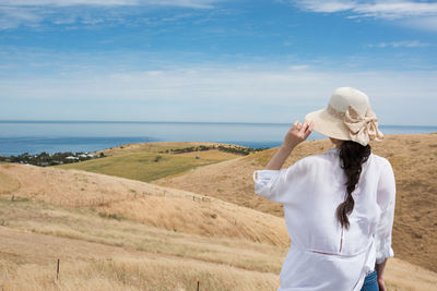 Rear view of woman on land against sky