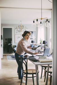 Woman sitting on table at home