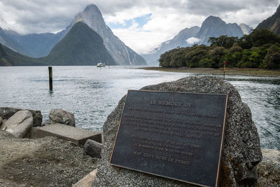 Fjord with impressive mountains in backdrop and monument in foreground. milford sound, new zealand