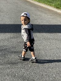 Portrait of cute boy standing on road