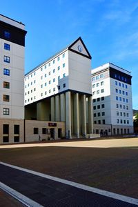 Low angle view of modern building against blue sky