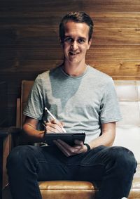 Portrait of young man using mobile phone at home