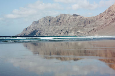 Scenic view of sea and mountains against sky