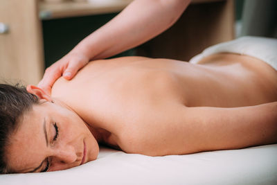 Back massage in a massage salon, woman having a relaxing back massage.