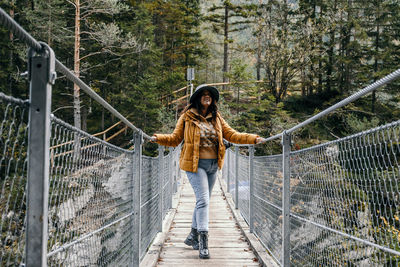 Full length of woman walking on footbridge