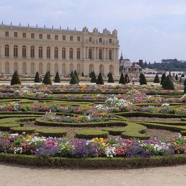 building exterior, flower, architecture, built structure, large group of people, city, sky, day, outdoors, freshness, person, abundance, travel destinations, plant, formal garden, incidental people, fragility, tourism, travel