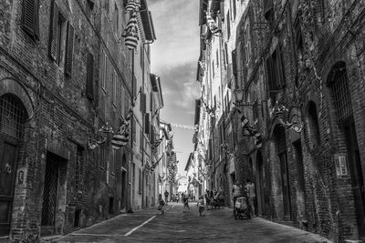 Alley amidst city against sky