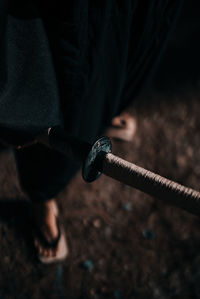 Low section of man holding cigarette at night