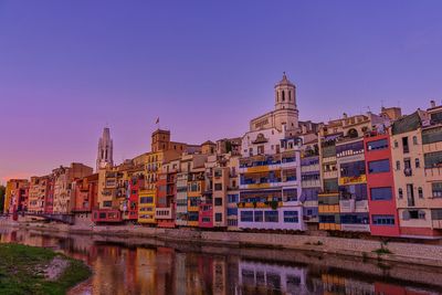 Buildings in city against clear blue sky