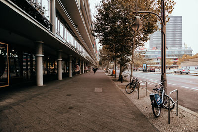 Bicycle on sidewalk by buildings in city