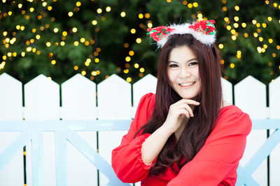 Portrait of smiling woman against christmas decoration